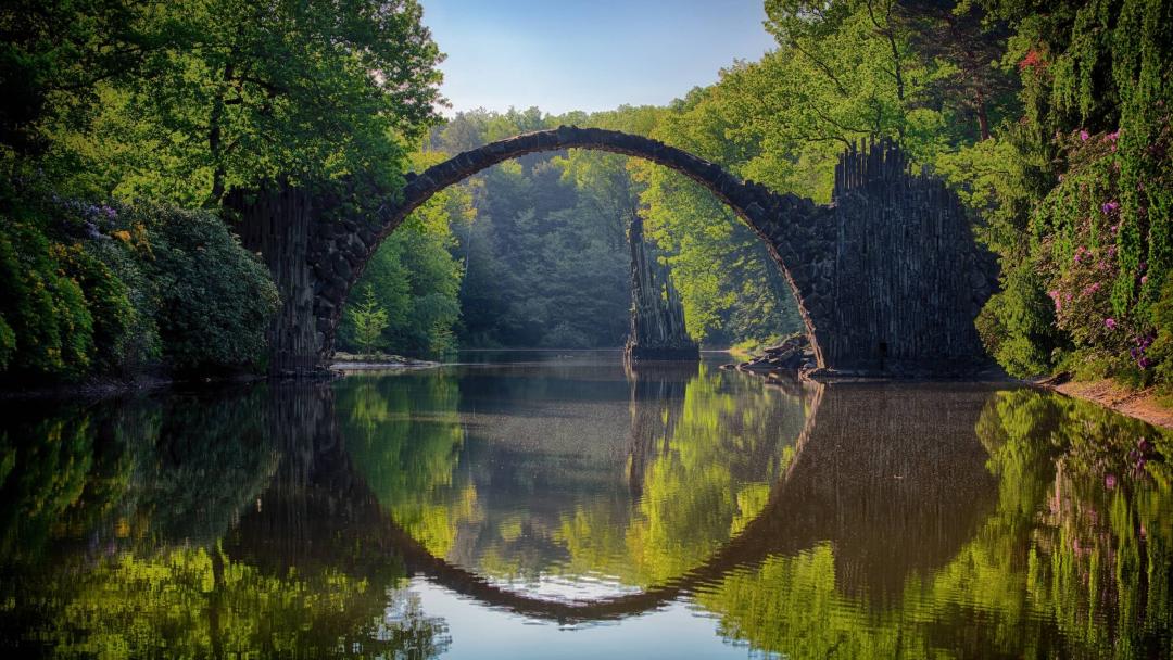 Stone bridge over lake in forest