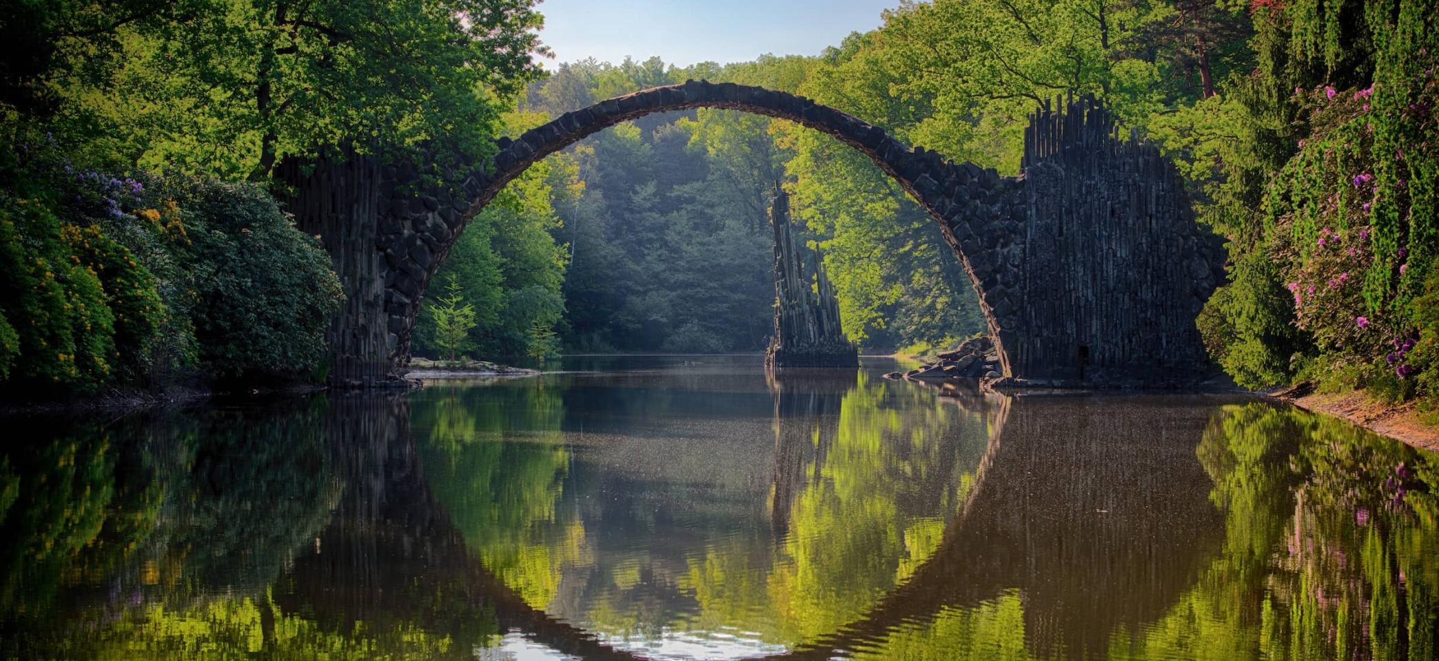 Stone bridge over lake in forest